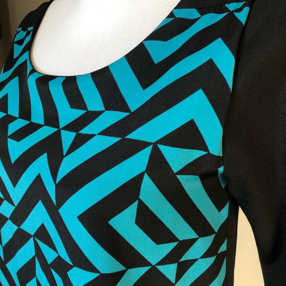 Small dress with two color geometric design on front and solid black on back.